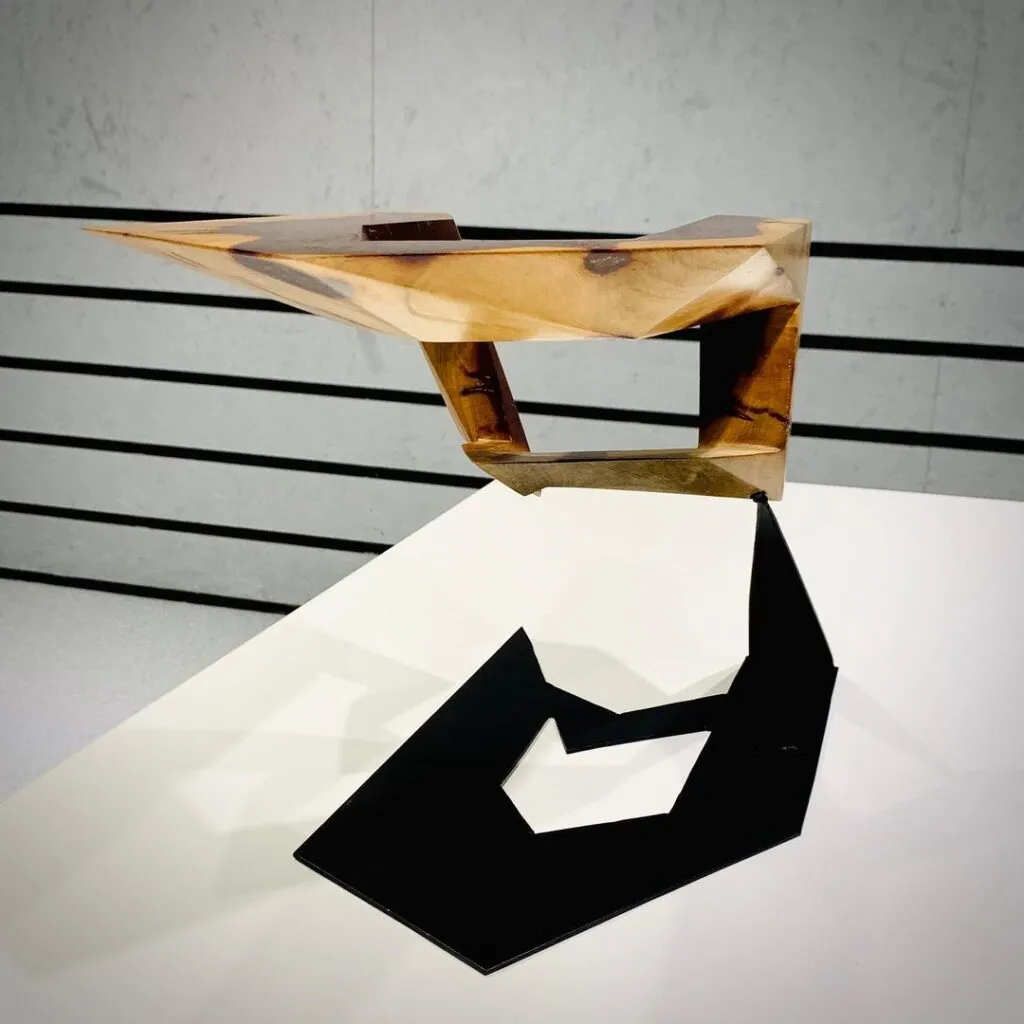 Escultura abstracta de madera de quebracho con base metálica, creada por el artista escultor arquitecto Javier Colomino