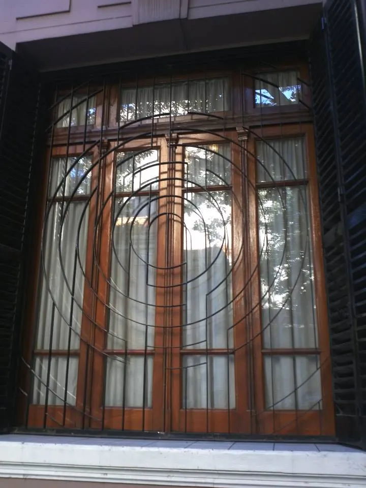 Rejas para ventanas de vivienda clásica de principios del siglo XX, diseño de Javier Colomino; hierro macizo rectangular con círculos concéntricos para un acabado artístico